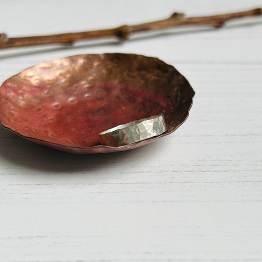 A 5mm wide silver ring with a beautifully classic hammered texture, by zoe ruth designs.