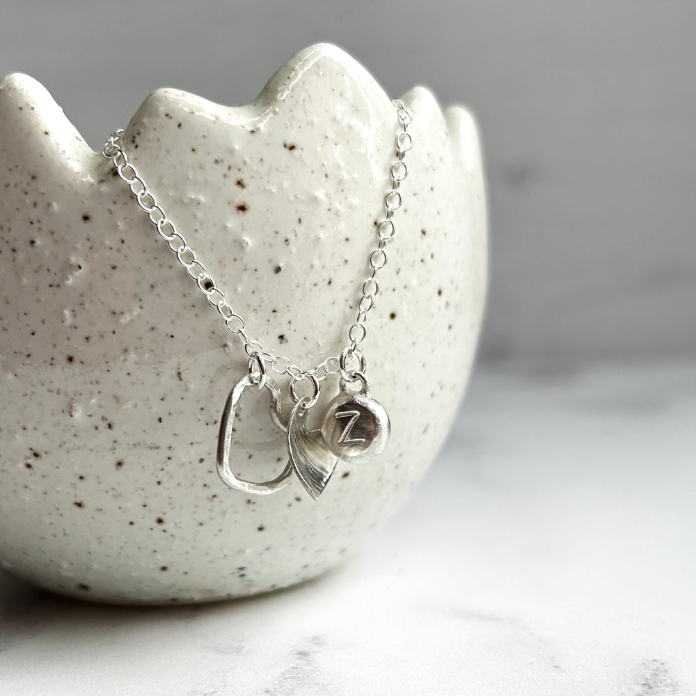 Necklace of handmade silver hearts and silver pebble with the letter Z stamped by zoe ruth designs