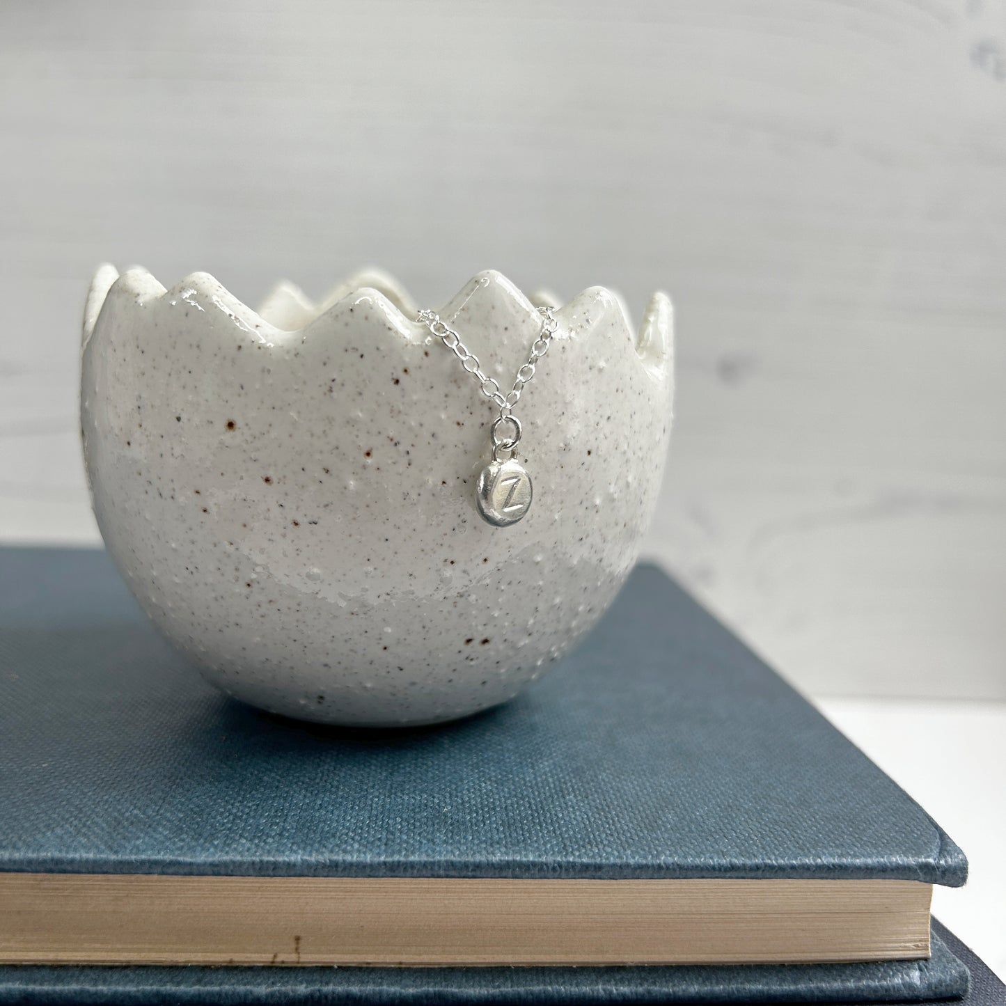 A sterling silver handmade pebble charm pendant with a stamped letter Z, by zoe ruth designs