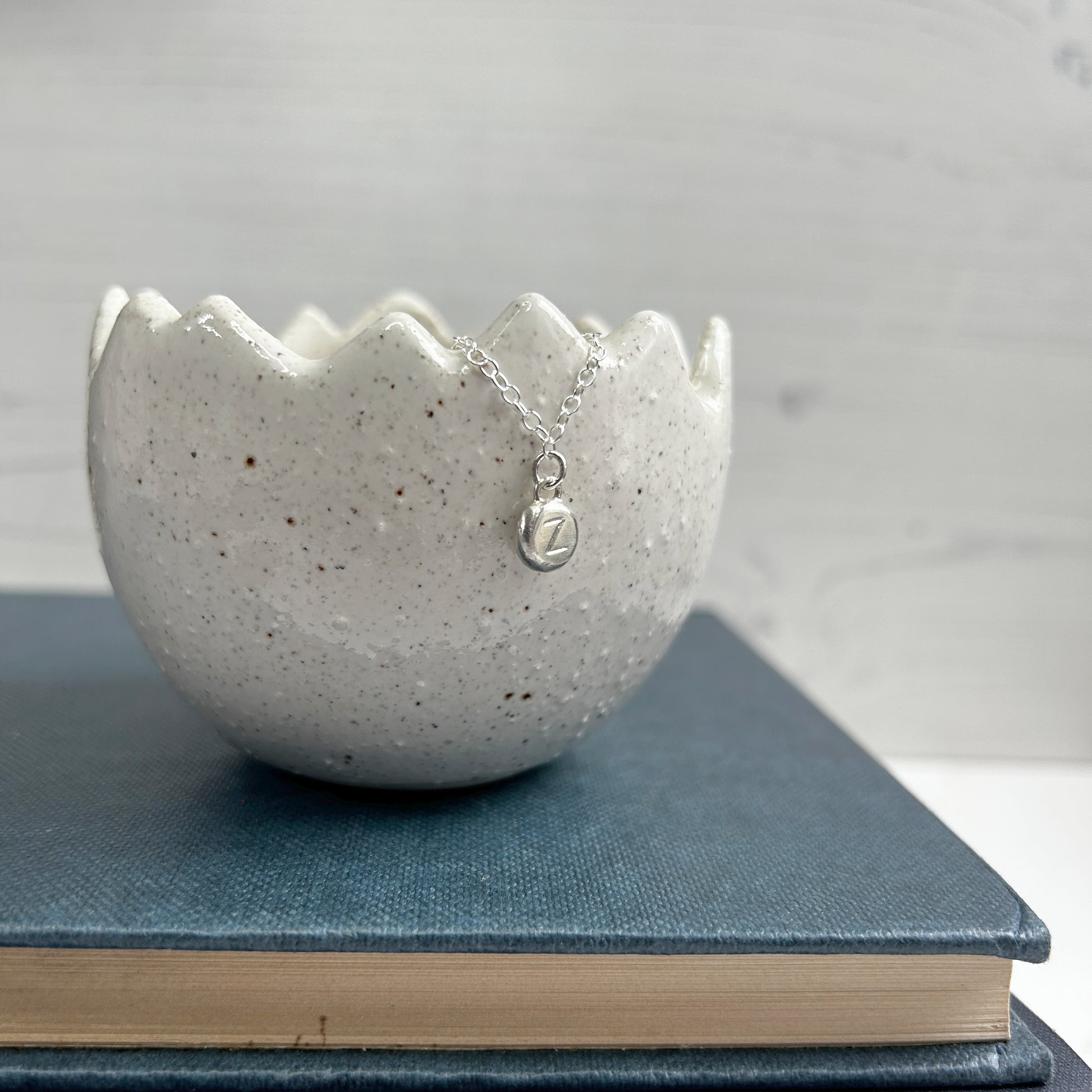 A sterling silver handmade pebble charm pendant with a stamped letter Z, by zoe ruth designs