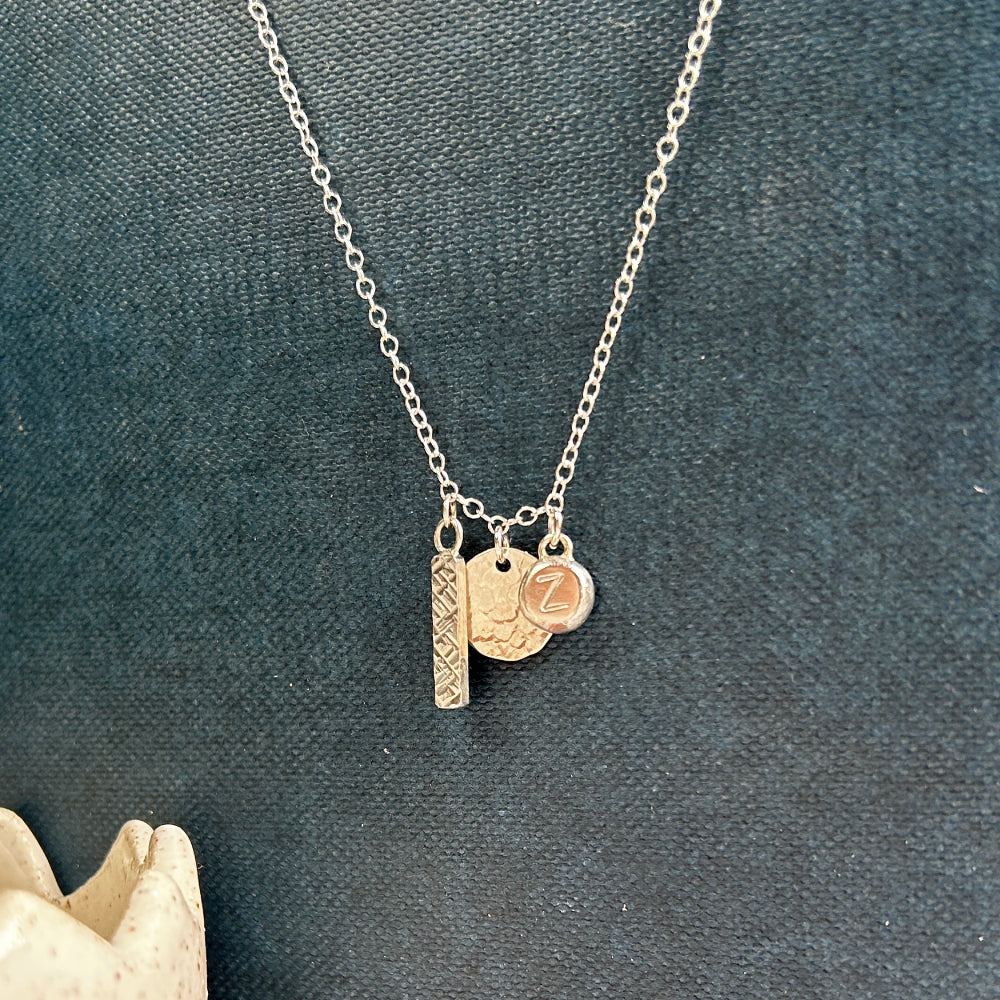 charm necklace with criss cross textured bar, dimple textured disk, letter stamped silver nugget by zoe ruth designs
