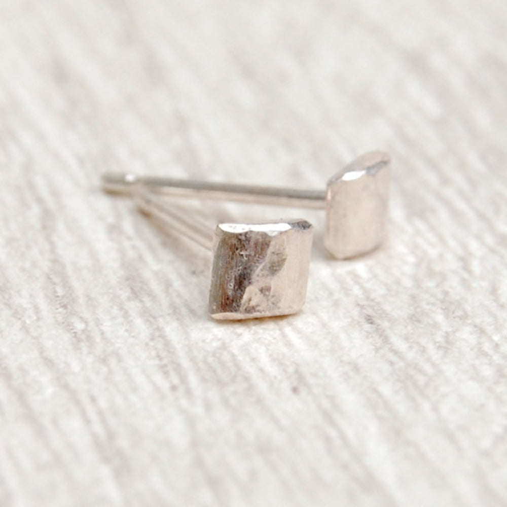 a pair of small silver square hammered stud earrings, by zoe ruth designs.