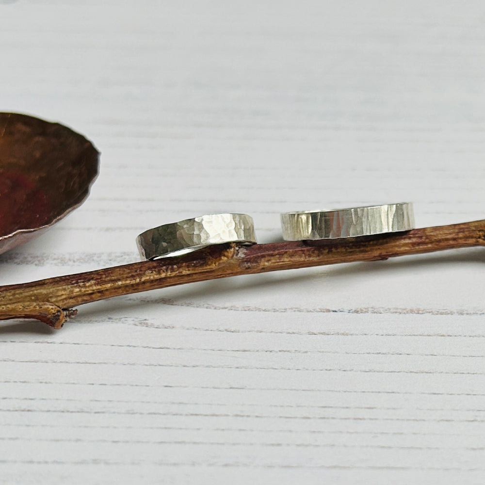Two 5mm wide silver rings with different textures, one a beautifully classic hammered texture and the other a linear treebark like texture, by zoe ruth designs.