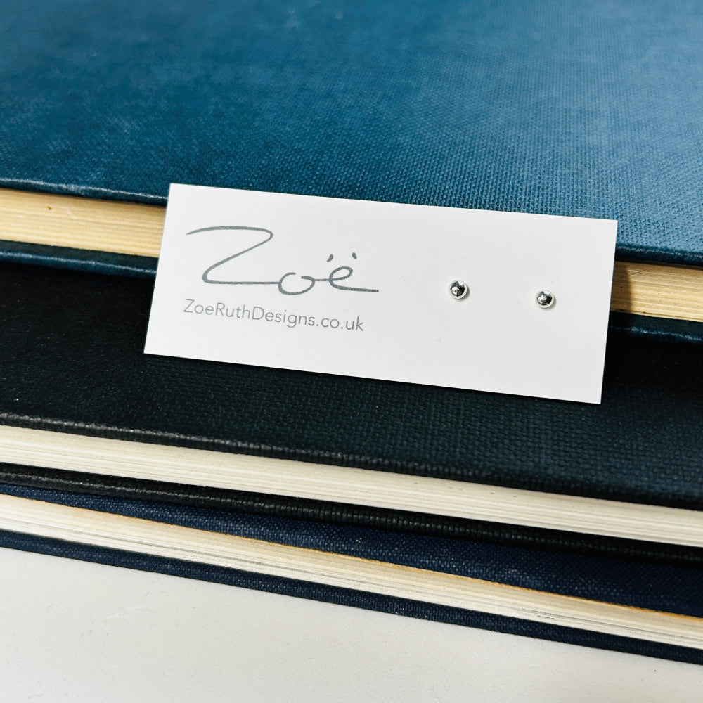Handmade sterling silver stud earrings displayed on their logo card packaging of Zoe Ruth Designs