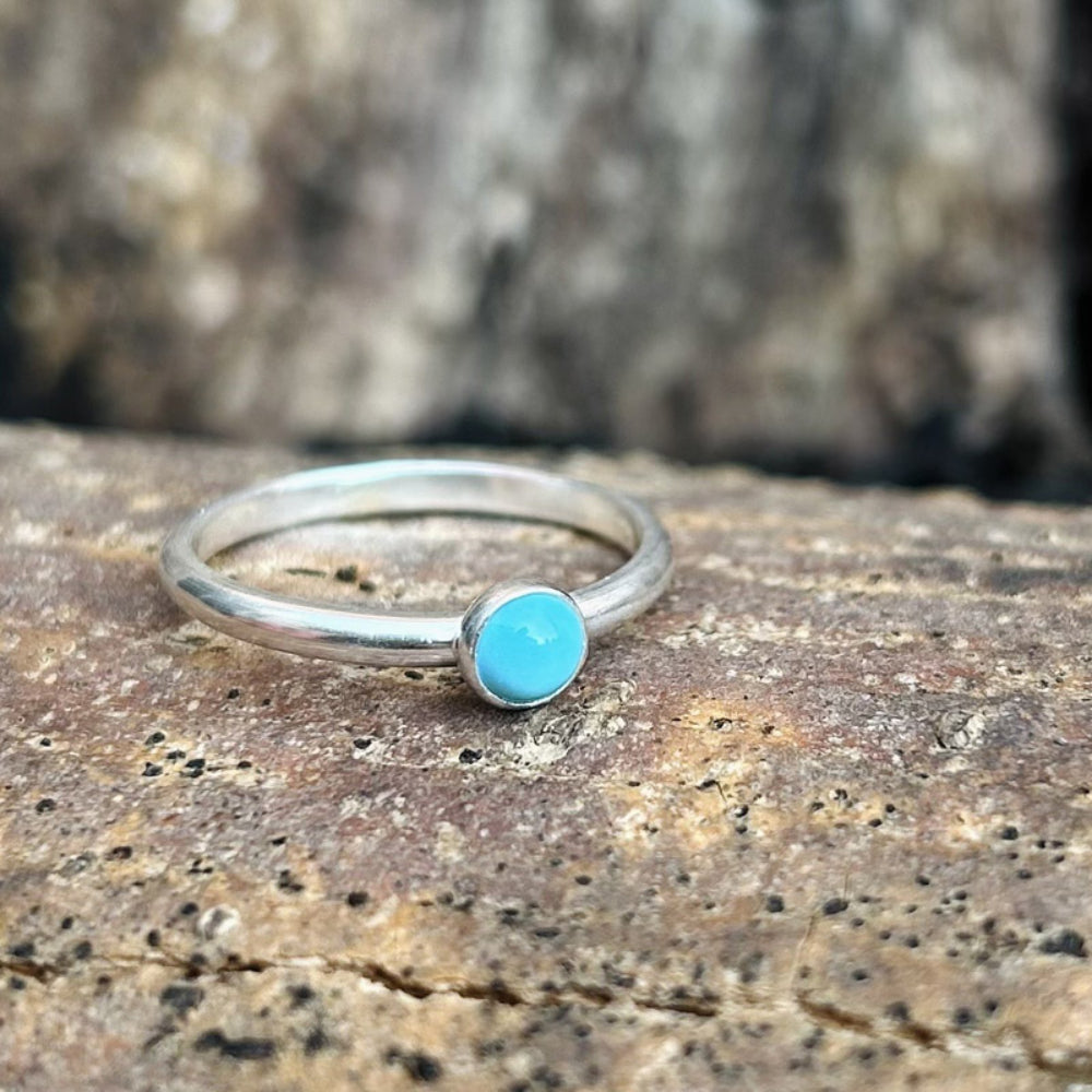 Showing a single pale turquoise stone set on a silver ring bnad, by zoe ruth designs