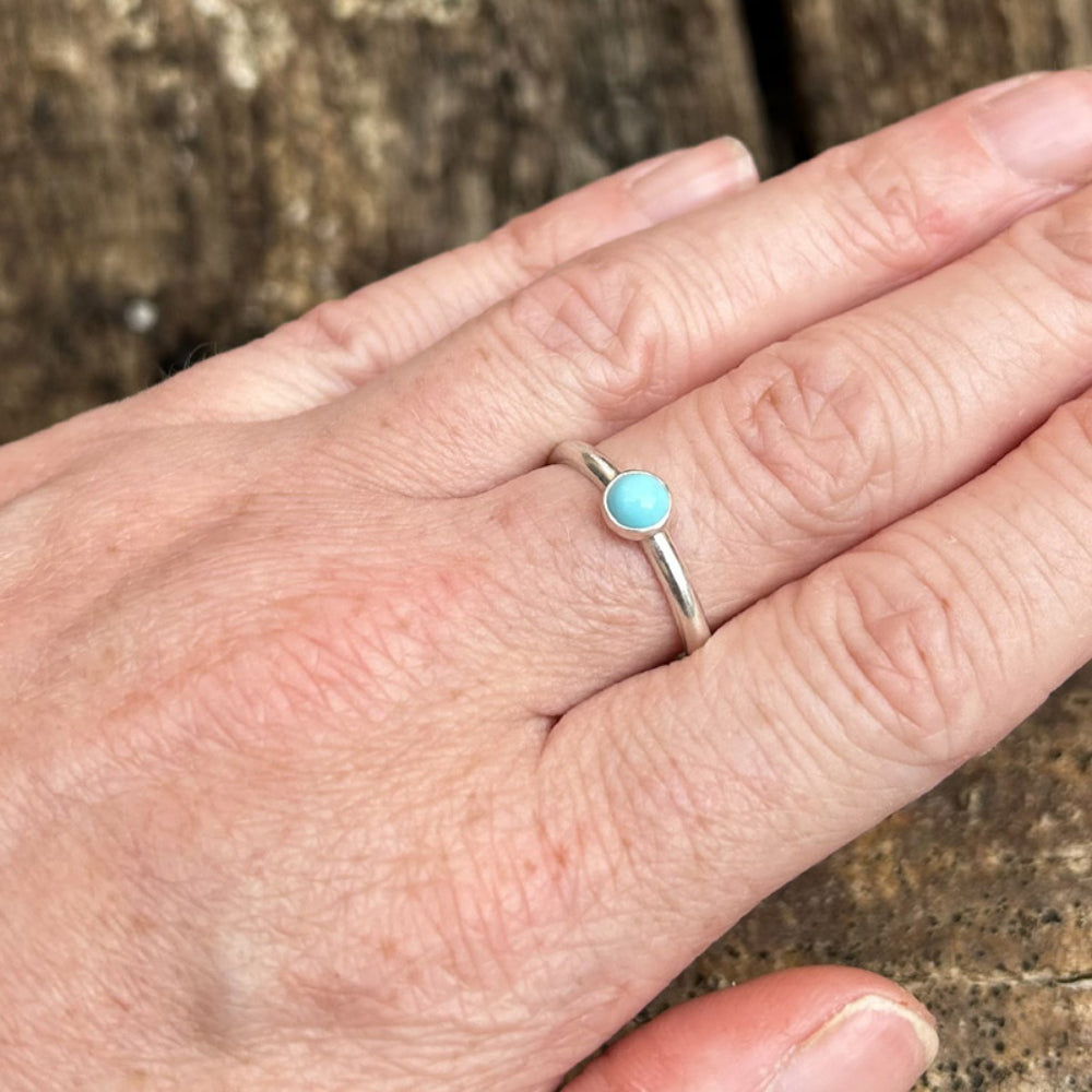 a single pale turquoise stone set on a silver smooth ring shown being worn, by zoe ruth design