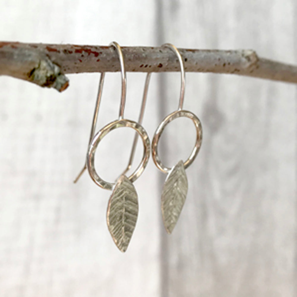 Silver hook earrings, open circle with solid silver leaf shape, scribed leaf detail, by zoe ruth designs.