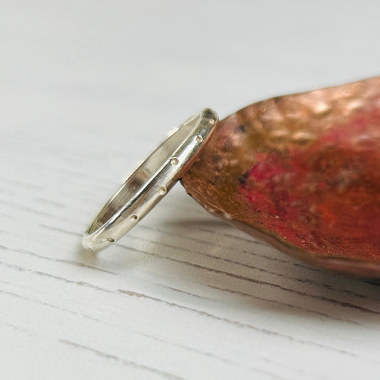 A handmade slim silver ring with a stamped dotty pattern, by zoe ruth designs