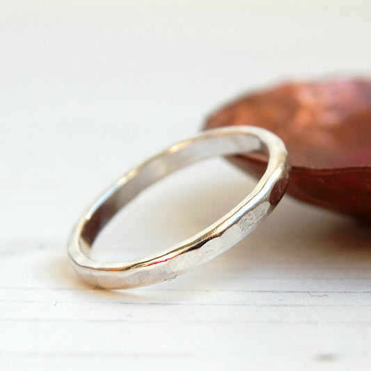 Showing a silver stacking ring with a flat hammerd texture on teh rounded ege of the ring, by zoe ruth designs