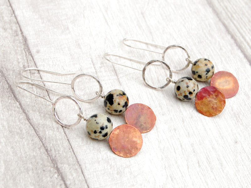 Two pairs of silver hook style earrings with an open silver circle at the top, a natural Jasper Dalmation stone, then a coloured copper disk below, to show the differences in the Jasper and the copper colour, by zoe ruth designs