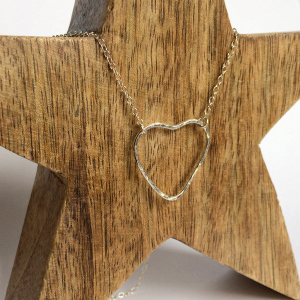 A sterling silver heart outline with a hammered surface sits at the focal point of the necklace, the chain being attacted by jumprings at two moveable places on the heart, by zoe ruth designs