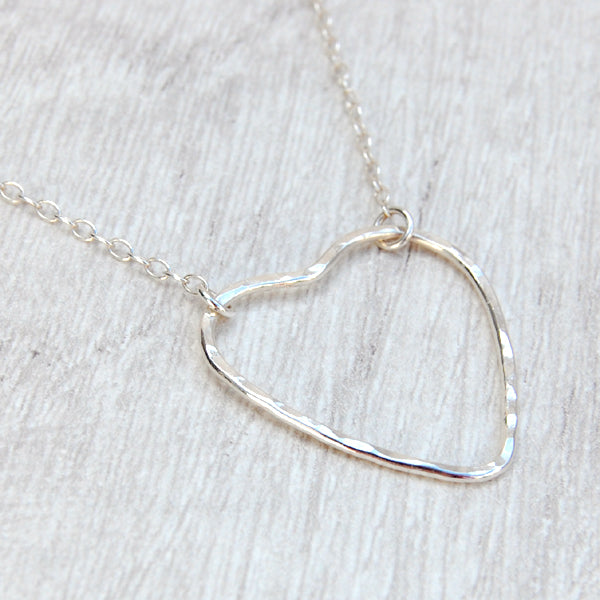 A sterling silver heart outline with a hammered surface sits at the focal point of the necklace, the chain being attacted by jumprings at two moveable places on the heart, by zoe ruth designs