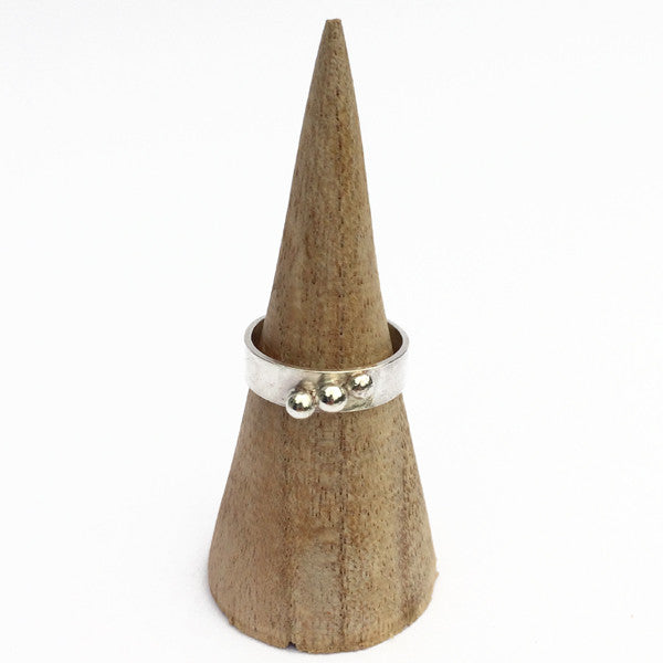 A 5mm wide smooth silver band with three silver balls soldered in a diagonalline across the width, b  zoe ruth designs.
