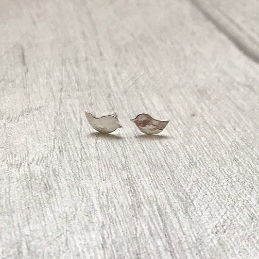 There are two small bird silhouettes in hammered silver to make these two stud earrings, by zoe ruth designs