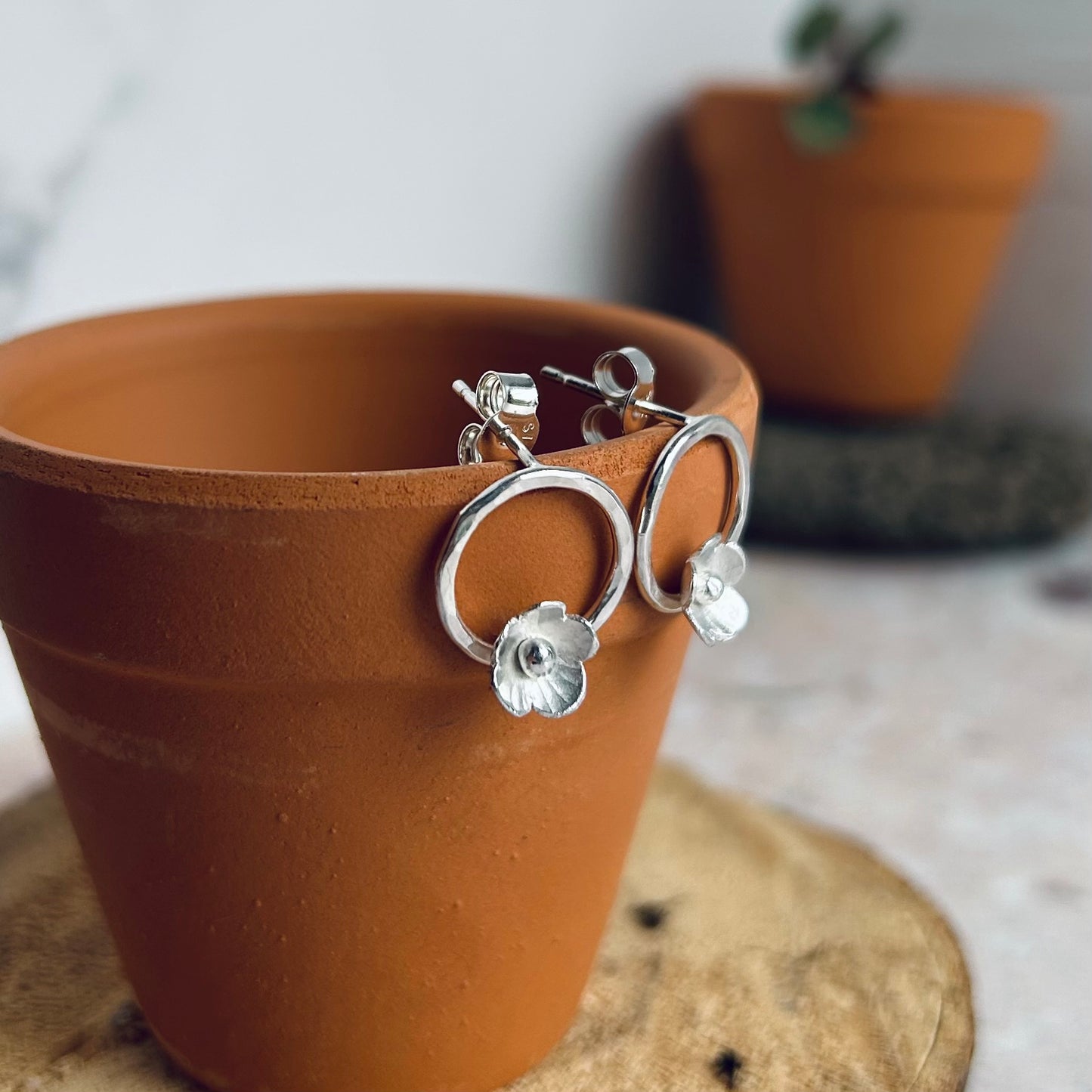 Silver flowers on silver circle studs