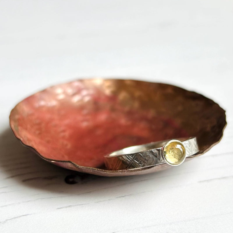 A handmade silver textured band ring with a round golden citrine stone