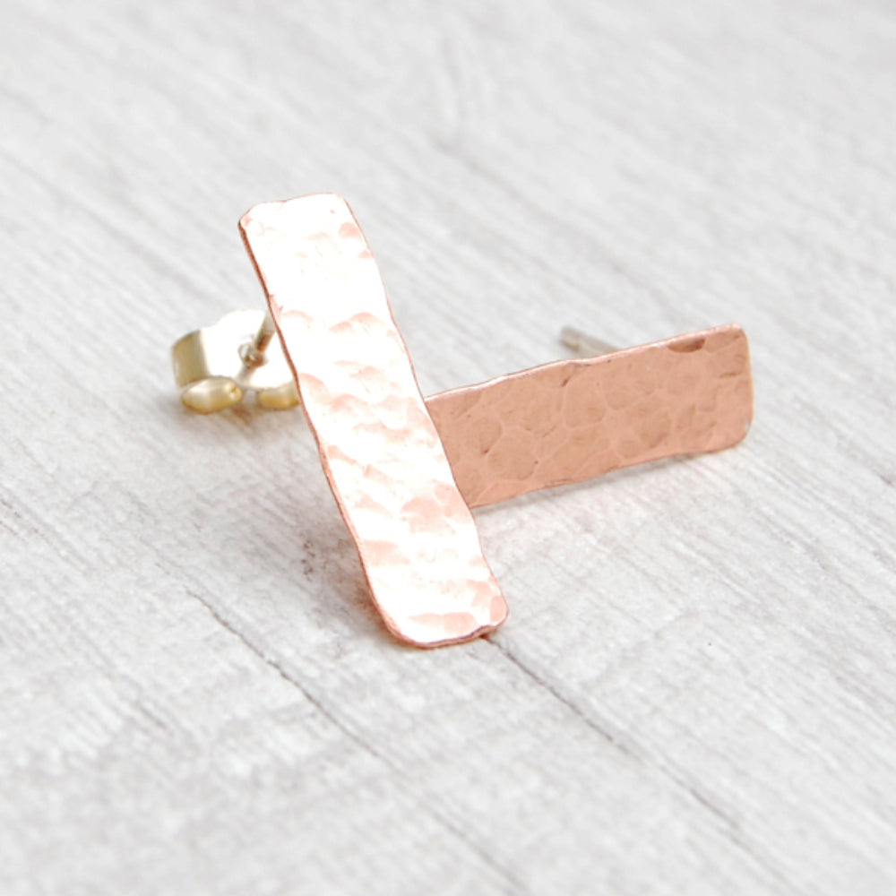 Slim rectangle shaped hammered surface copper stud earrings, diplayed to catch the light, by zoe ruth designs