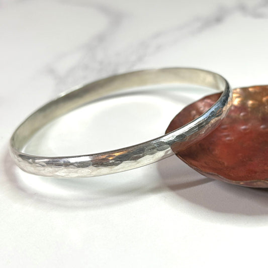 A hammered sterling silver bangle showing the texture