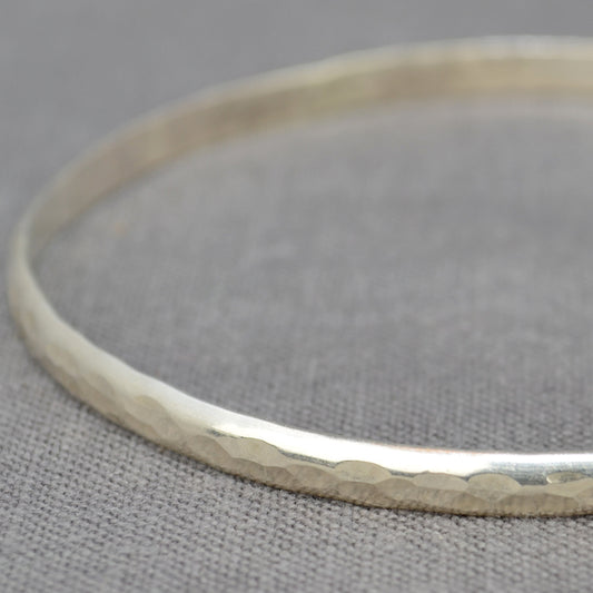 A classic hammered D profile silver bangle shown in close up for the detail, by zoe ruth designs