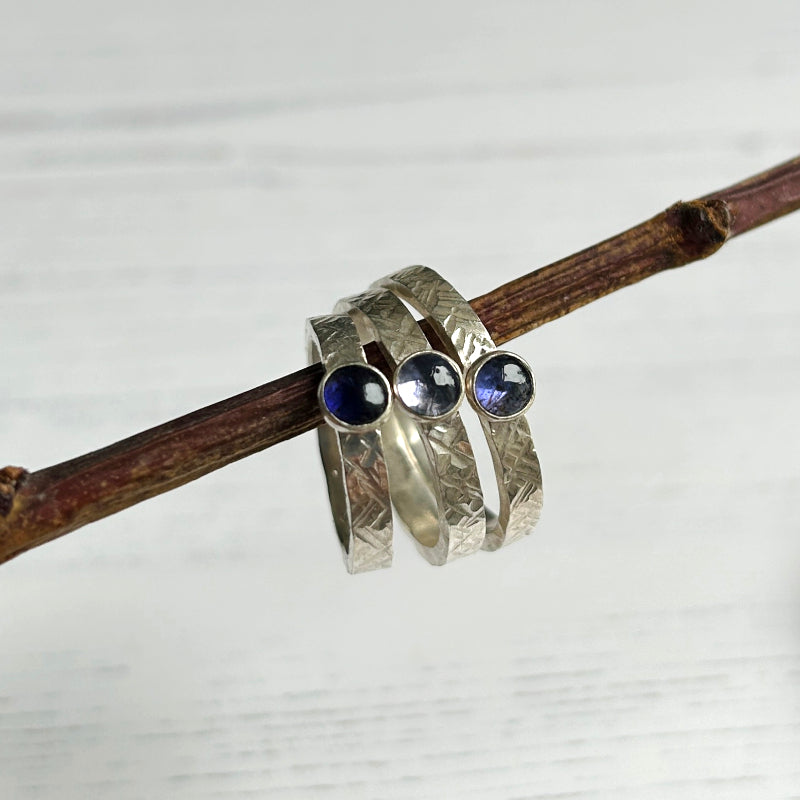 showing three rings with graduated shades of blue as naturally found in iolite stones