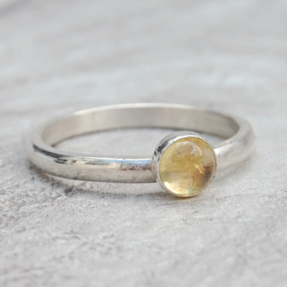 A smooth slim silver ring with a yellow citrine stone set on it, by zoe ruth designs