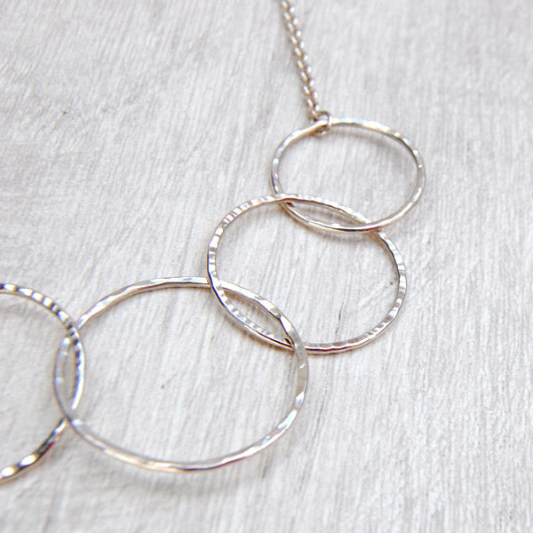 close up of three silver links circles showing the different textures on the surface, by zoe ruth designs