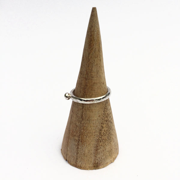 Showing a hammered surface silver slim ring with a single silver small round pebble shape on the surface, by zoe ruth designs